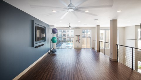 a living room with a hard wood floor and a ceiling fan