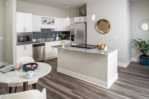 a kitchen with white cabinets and a marble counter top