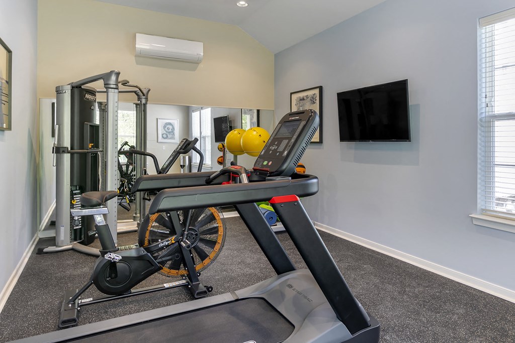 a home gym with exercise equipment and a tv