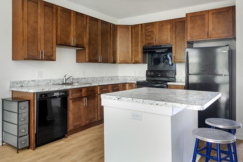 a kitchen with marble counter tops and black appliances