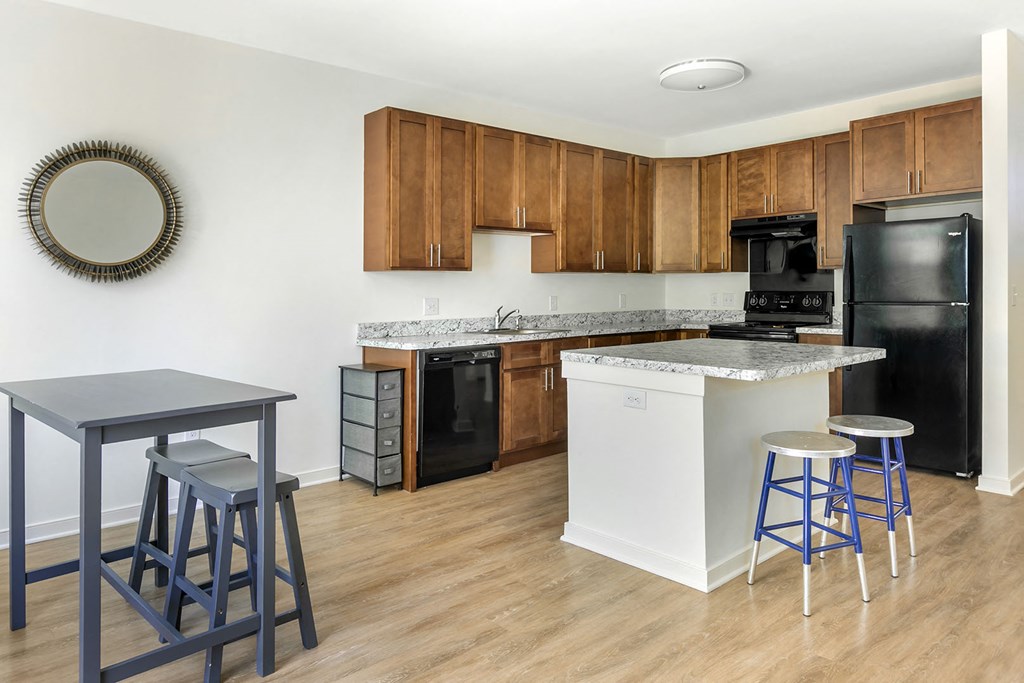 a kitchen with an island and a bar with three stools