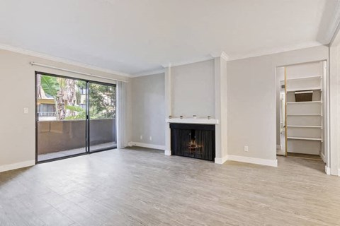 an empty living room with a fireplace and a sliding glass door