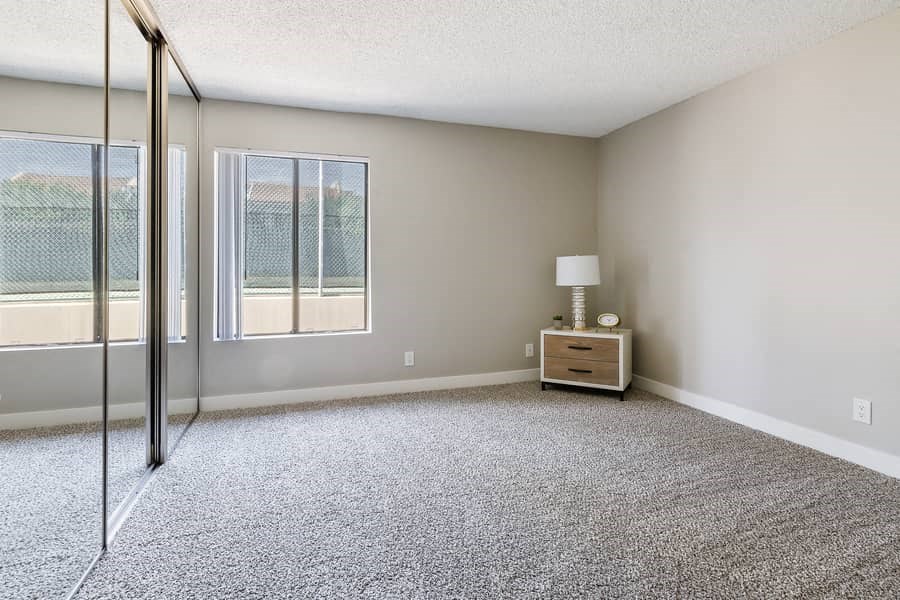 an empty living room with sliding glass doors to a balcony
