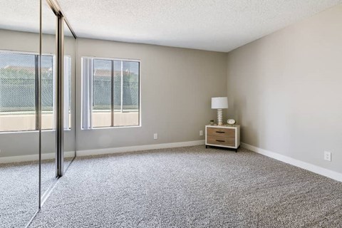 an empty living room with sliding glass doors to a balcony