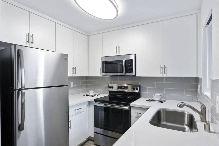 a kitchen with stainless steel appliances and white cabinets