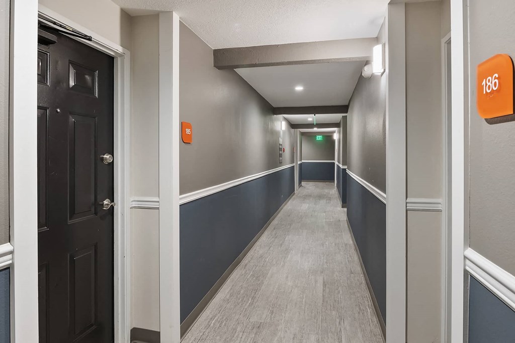 a hallway with a black door and a hall way with a blue and white corridor