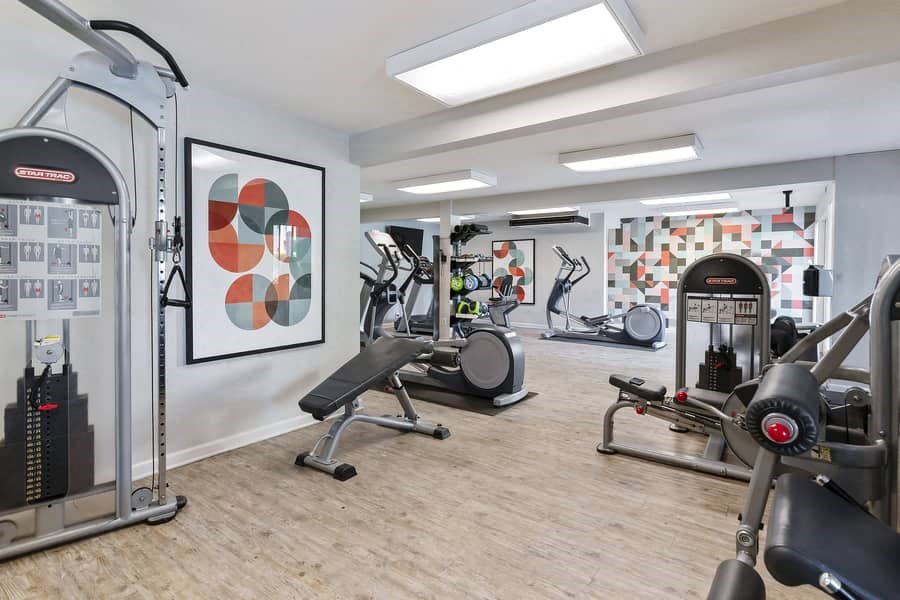 a gym with exercise equipment and paintings on the wall