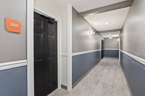 a hallway with blue walls and a black door