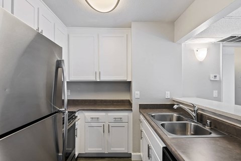a kitchen with stainless steel appliances and white cabinets