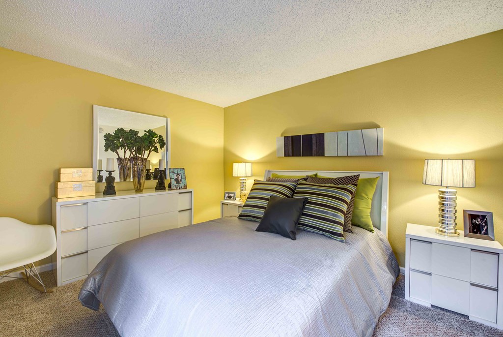a bedroom with a large bed and yellow walls