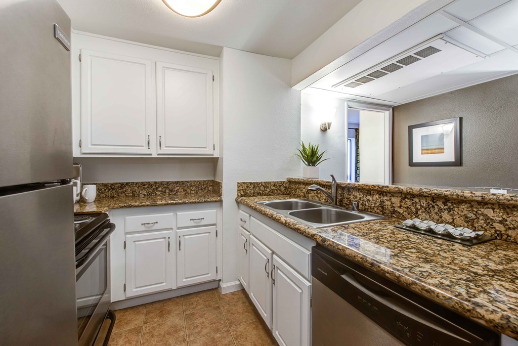 a kitchen with granite counter tops and stainless steel appliances