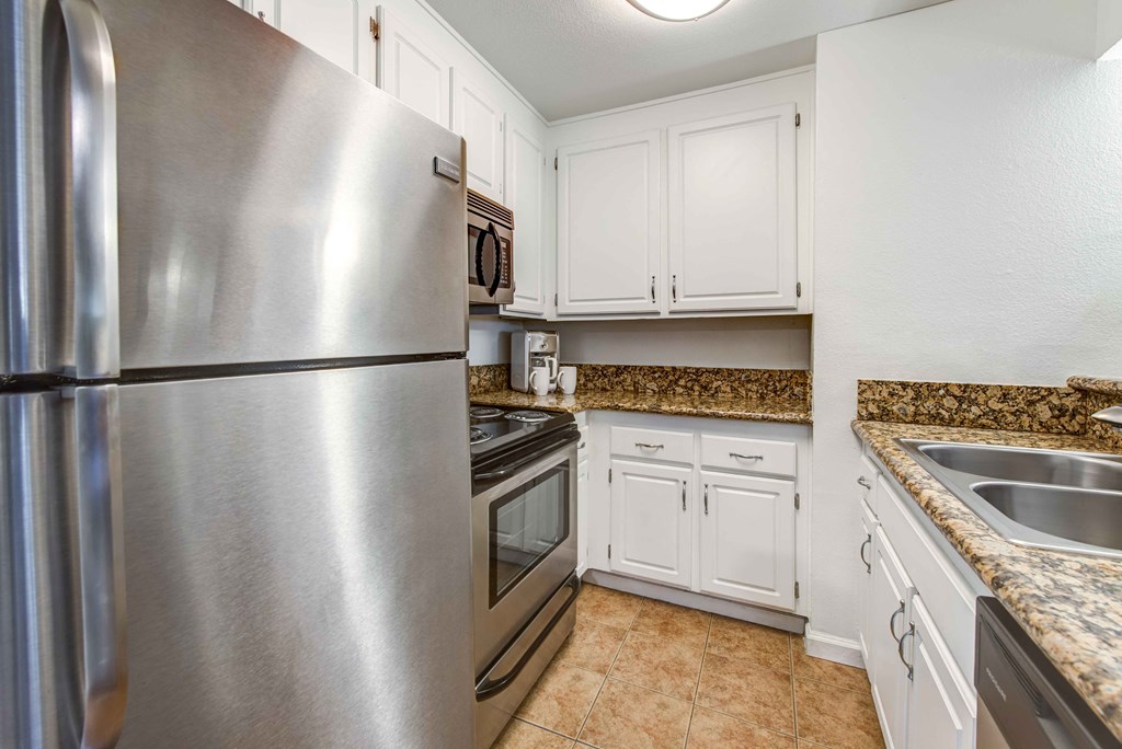 a kitchen with stainless steel appliances and white cabinets