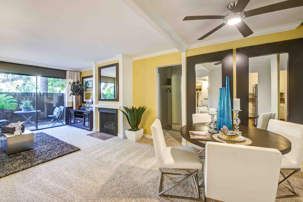 a living room with yellow walls and a table and chairs