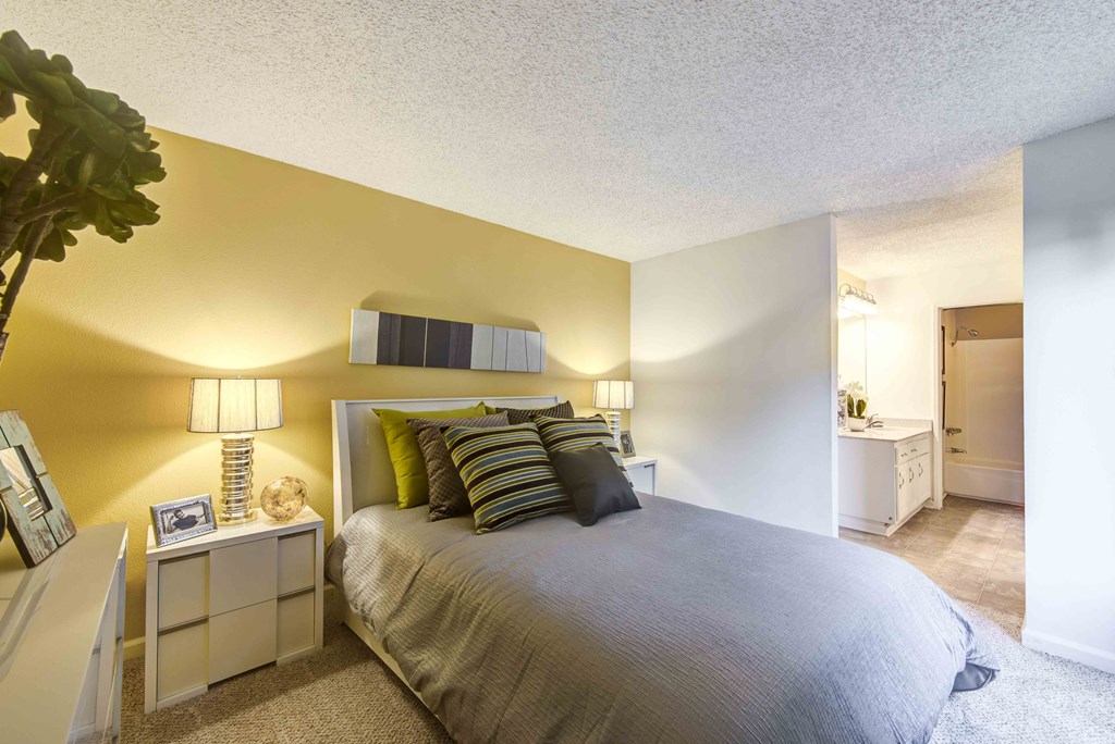 a bedroom with a large bed and a bathroom