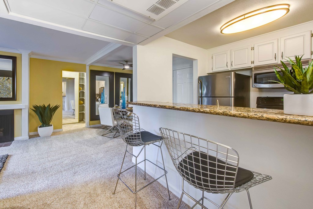 a living room with a bar and a kitchen