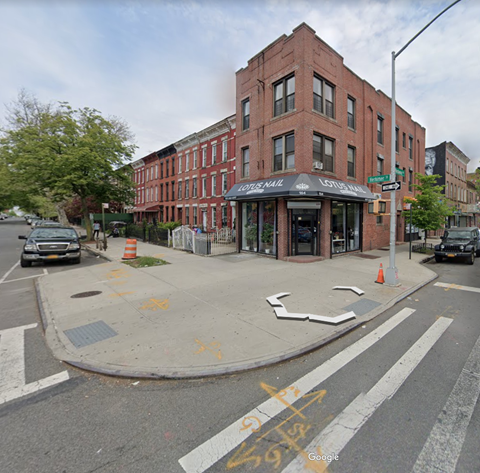 A street view of a crosswalk with a building in the background.