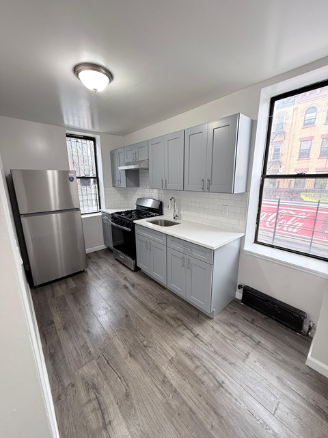 A kitchen with a stainless steel refrigerator and a white countertop.