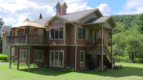 a house with a deck and a mountain in the background
