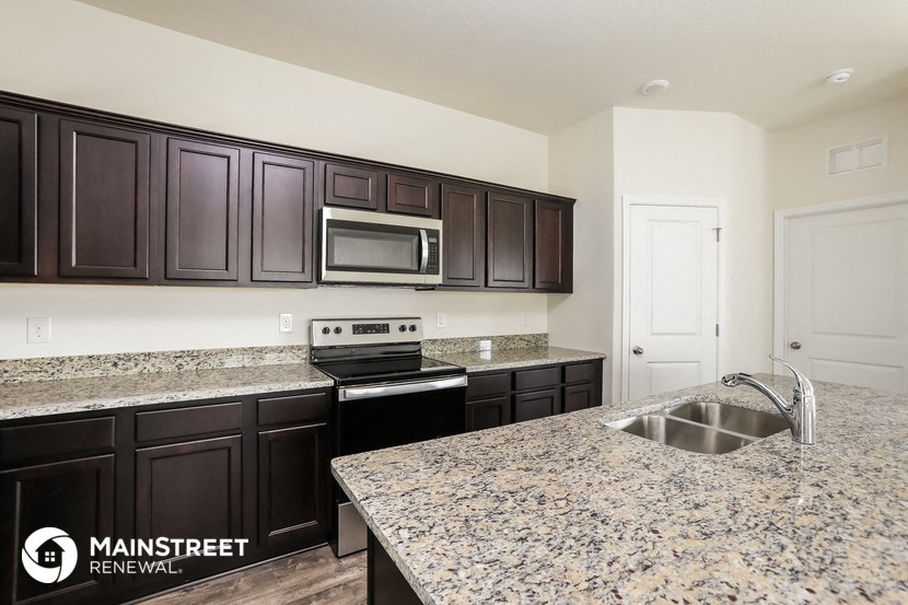 a kitchen with granite counter tops and black cabinets