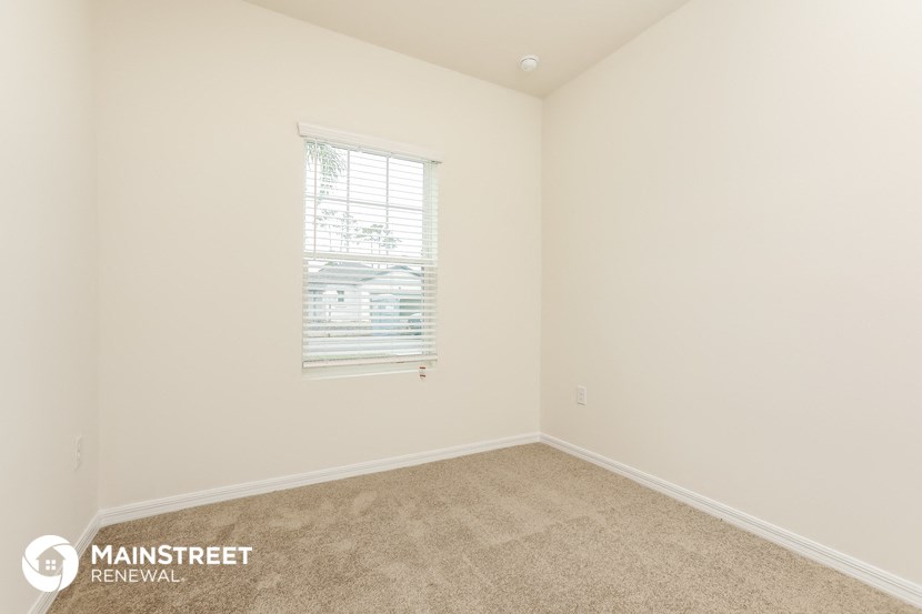 a bedroom with a carpeted floor and a window