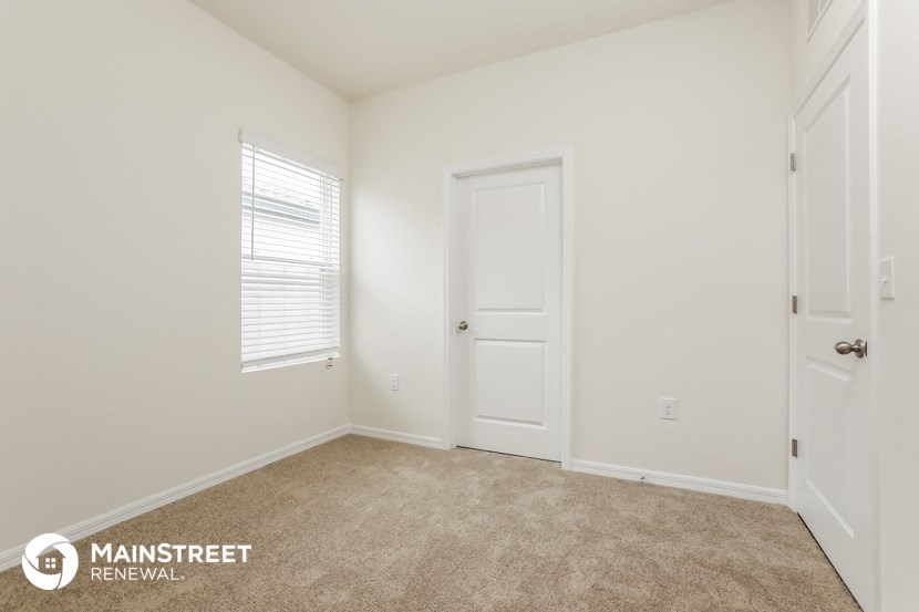 a bedroom with a carpeted floor and a white door