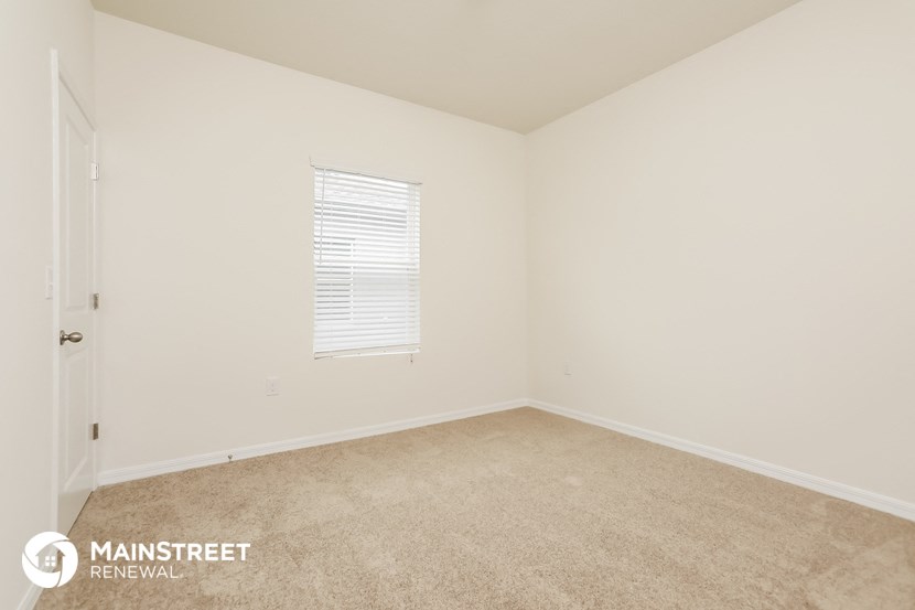 the living room of a home with carpet and a window