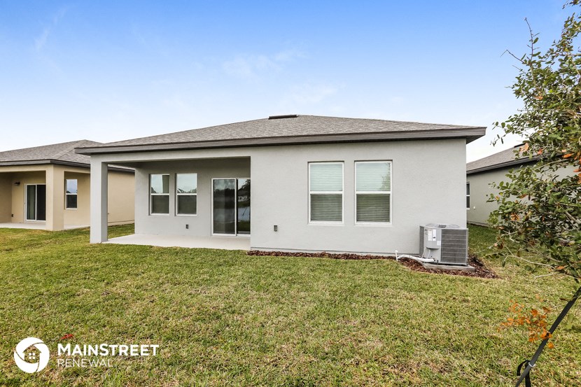 a white house with a grassy yard and a roof