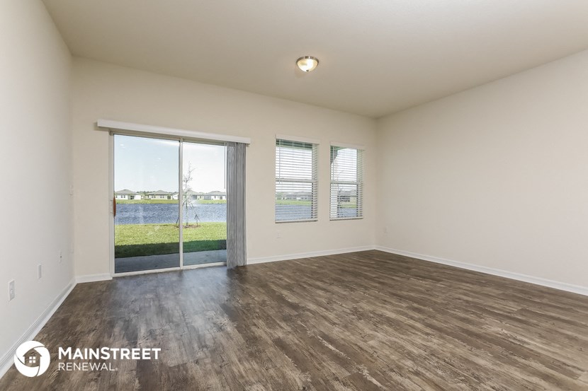 an empty living room with a view of the water