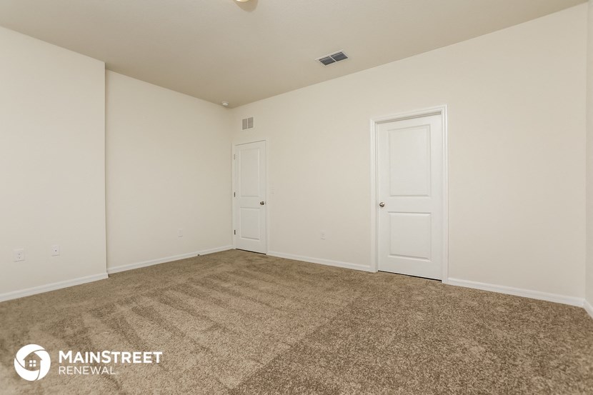 the living room of a home with carpet and white doors