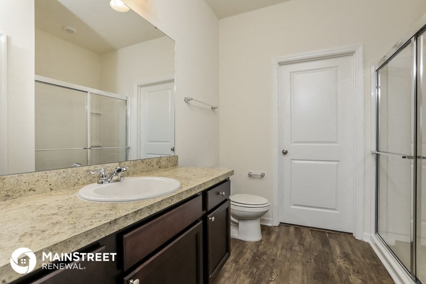 a bathroom with a sink and a toilet and a shower