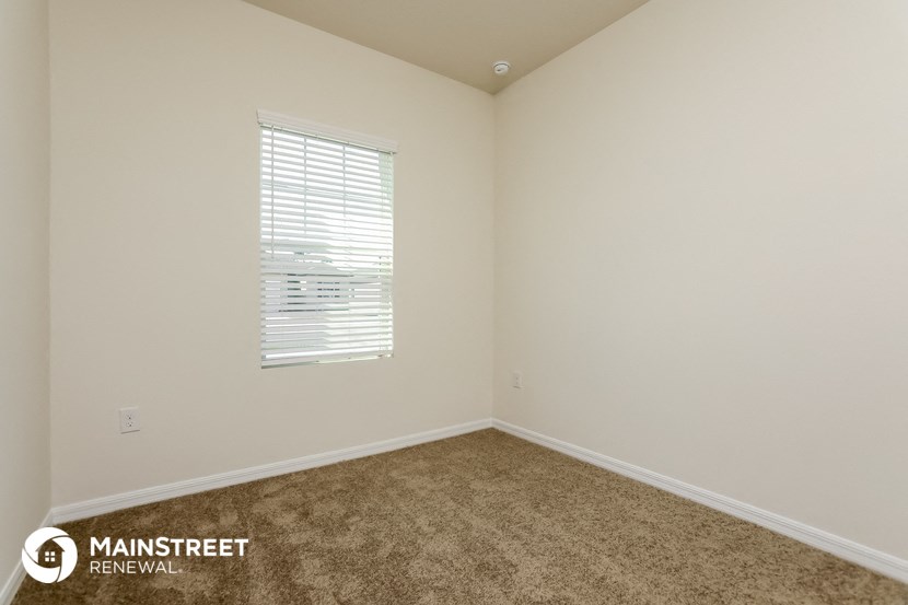the living room of a home with carpet and a window