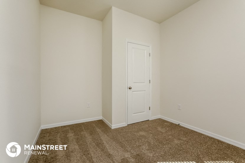 a bedroom with a carpeted floor and a white door