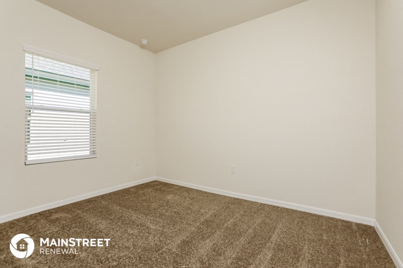 the living room of a home with carpet and a window