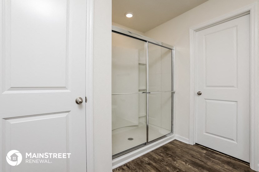 a white closet with a glass shower in it