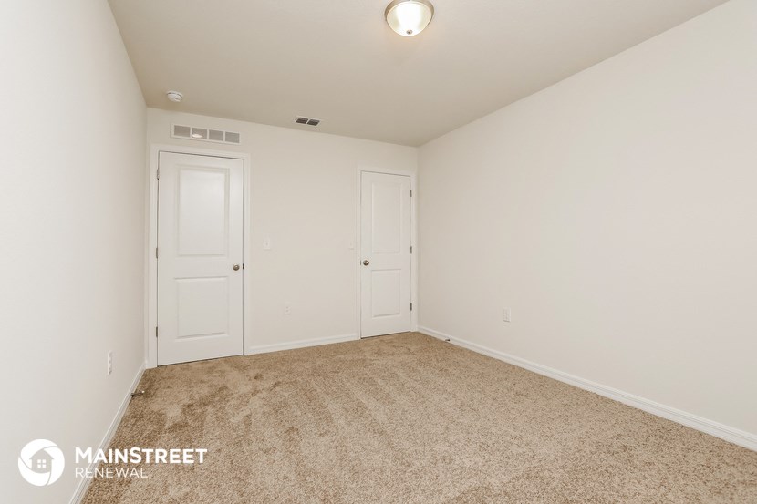 a bedroom with two closets and a carpeted floor