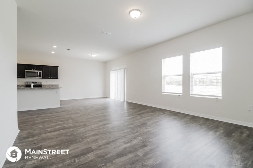 the living room and kitchen of a new home with wood flooring
