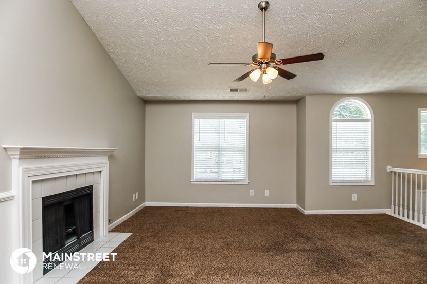 the living room with fireplace and ceiling fan