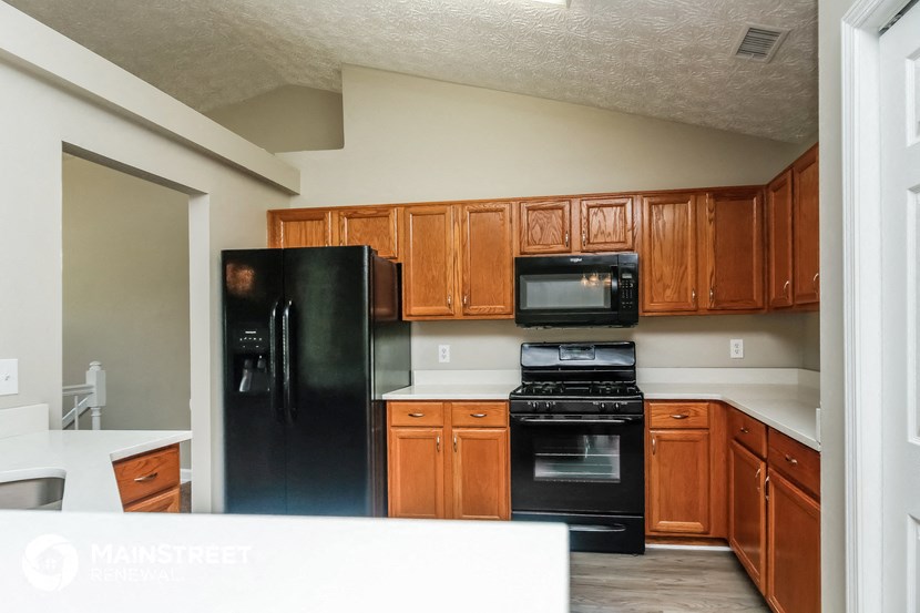a kitchen with black appliances and wooden cabinets