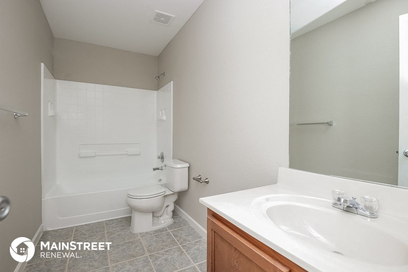 a bathroom with a sink toilet and tub and a mirror