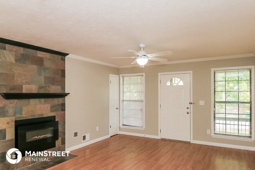 a living room with a fireplace and a ceiling fan