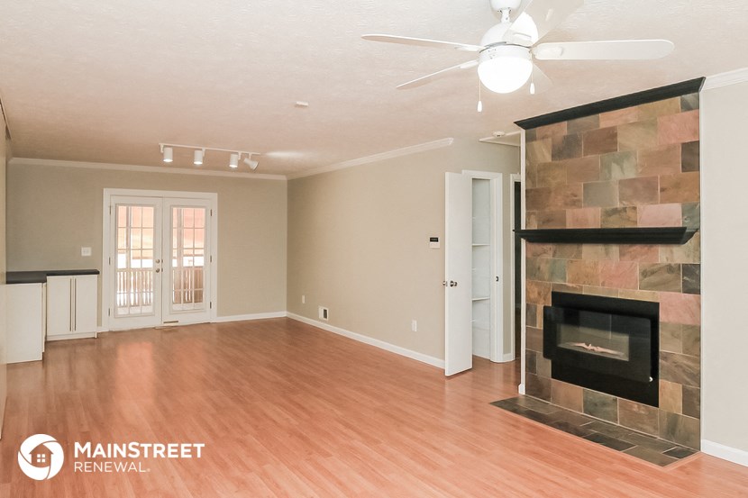 a living room with a fireplace and a wooden floor