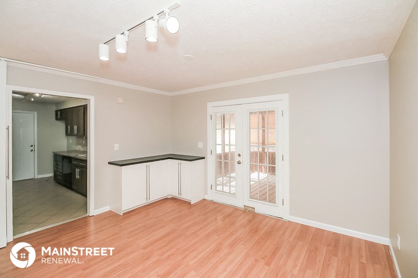 the living room and dining room with wood flooring and a door to the kitchen