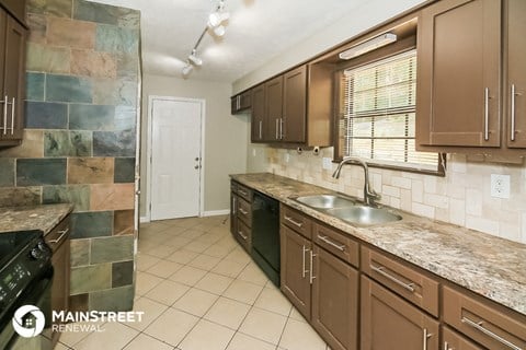 a kitchen with brown cabinets and a sink