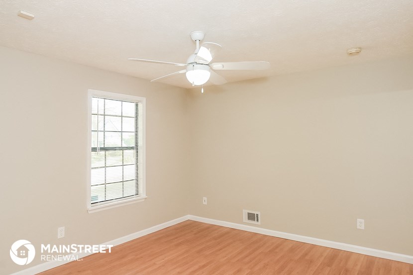 a living room with a ceiling fan and a window