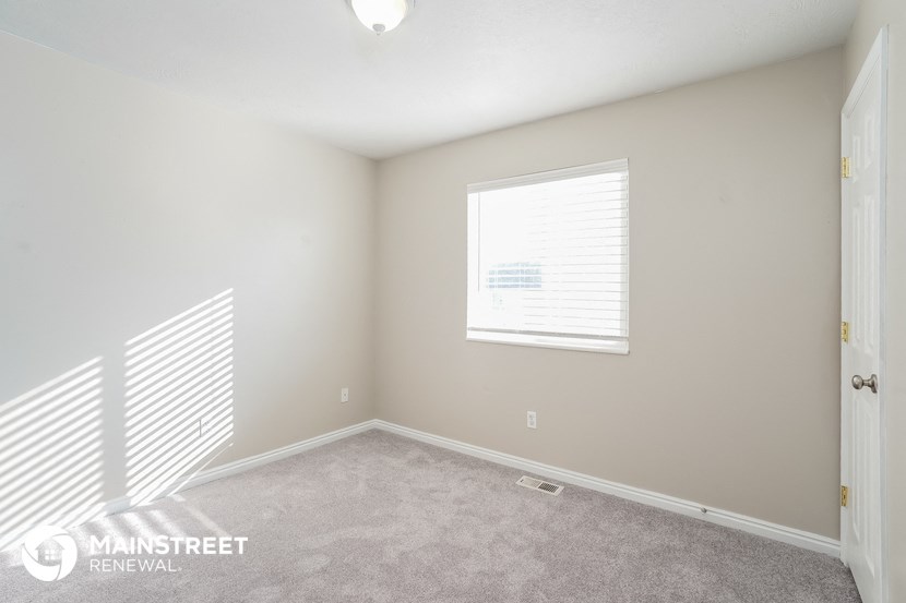 a bedroom with a carpeted floor and a window