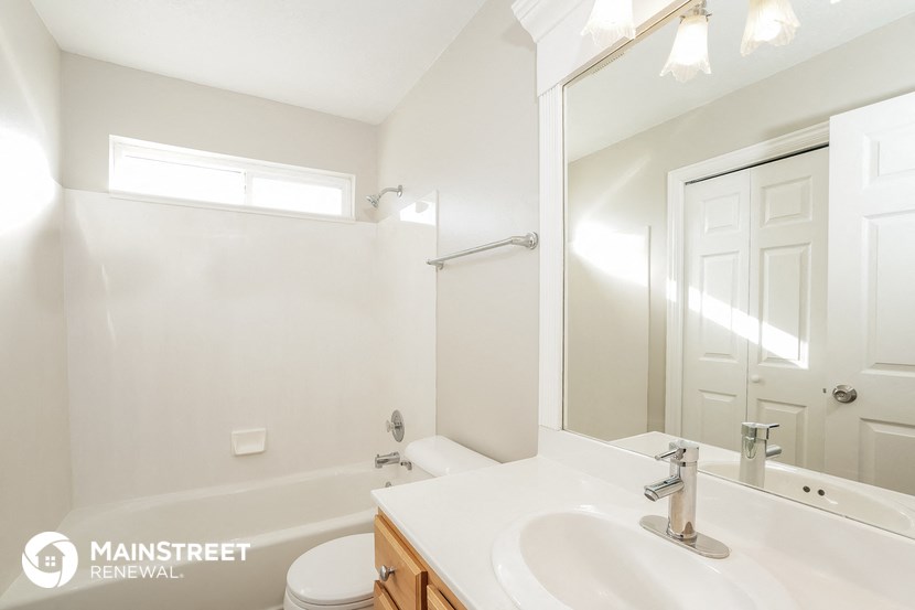 a bathroom with a sink and a mirror and a shower and a toilet