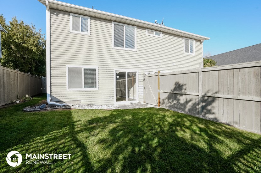 the back of a house with a yard and a fence