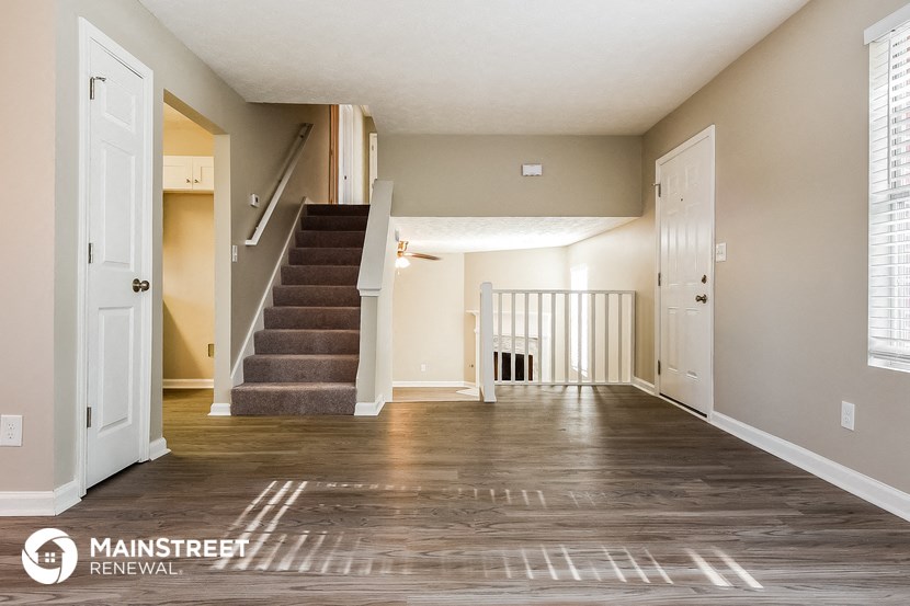 the living room and staircase of an empty house