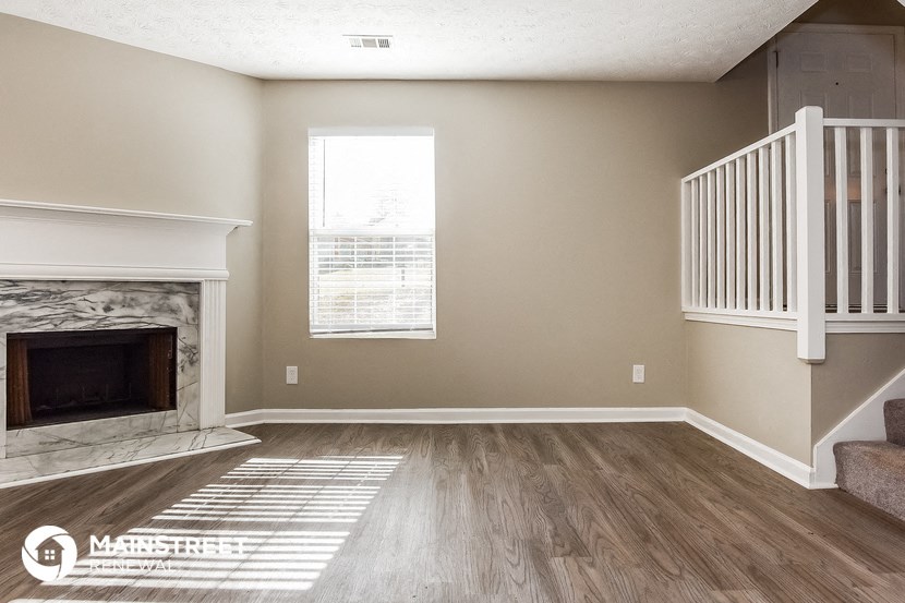 the living room of a new home with a fireplace and stairs