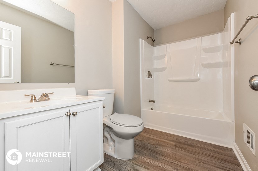 a bathroom with a toilet and a sink and a shower